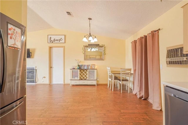 22780 Shawnee Rd, Apple Valley, CA 92308 - dining area with vaulted ceiling, light wood-style floors, a chandelier, and a textured ceiling