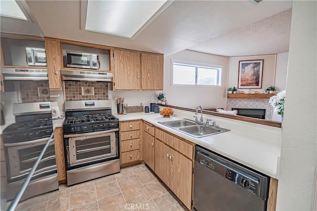 18209 Sierra Unit 45, Canyon Country, CA 91351 - kitchen with stainless steel appliances, under cabinet range hood, a sink, light countertops, and decorative backsplash