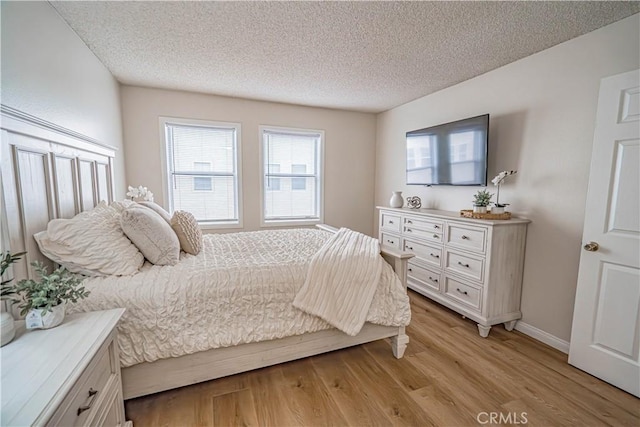 18209 Sierra Unit 45, Canyon Country, CA 91351 - bedroom featuring a textured ceiling, light wood-style flooring, and baseboards