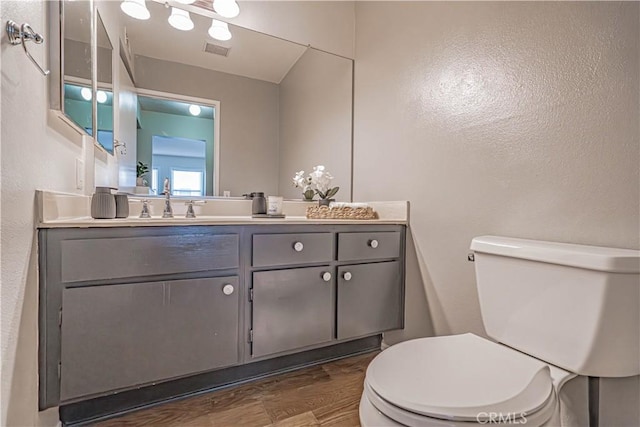 18209 Sierra Unit 45, Canyon Country, CA 91351 - bathroom with toilet, vanity, wood finished floors, and a textured wall