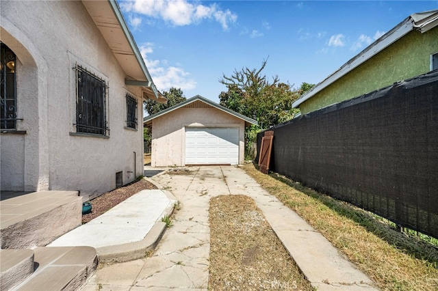 614 N Spring Ave, Compton, CA 90221 - view of property exterior featuring stucco siding, driveway, a garage, and an outdoor structure