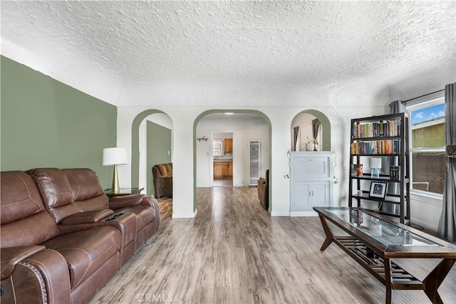 614 N Spring Ave, Compton, CA 90221 - living area with arched walkways, wood finished floors, a textured ceiling, and baseboards