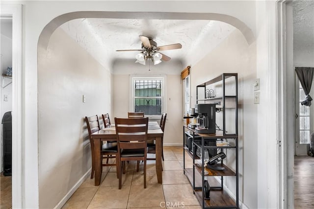 614 N Spring Ave, Compton, CA 90221 - dining room featuring arched walkways, ceiling fan, a textured ceiling, baseboards, and light tile patterned floors
