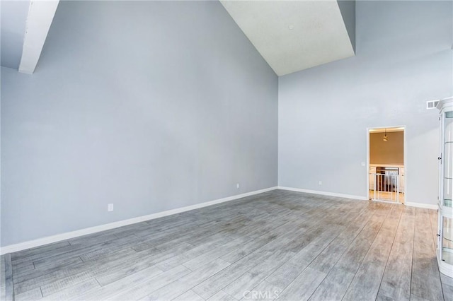 1320 Shadow Cir, Upland, CA 91784 - empty room with light wood finished floors, high vaulted ceiling, and baseboards