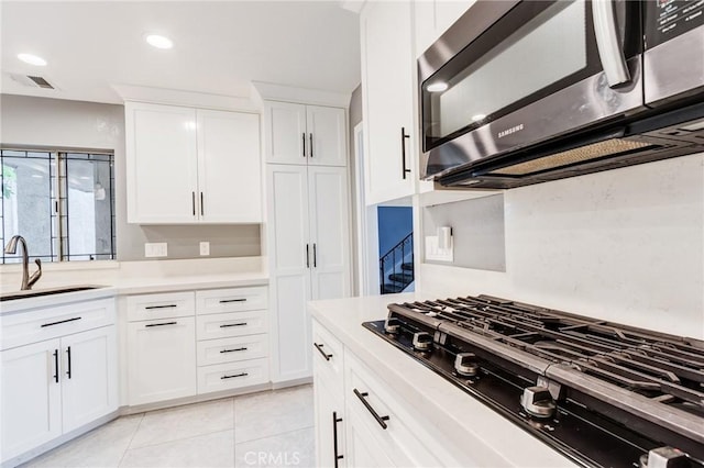 1320 Shadow Cir, Upland, CA 91784 - kitchen featuring stainless steel microwave, black gas stovetop, a sink, light countertops, and white cabinetry