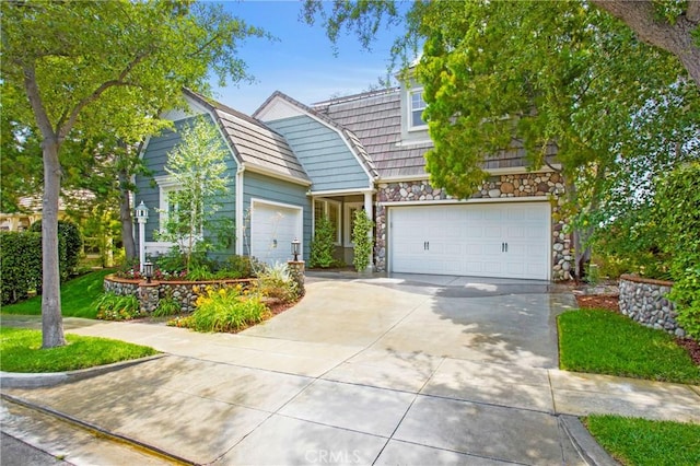 15 Beacon, Ladera Ranch, CA 92694 - view of front of property featuring concrete driveway, stone siding, an attached garage, and a gambrel roof
