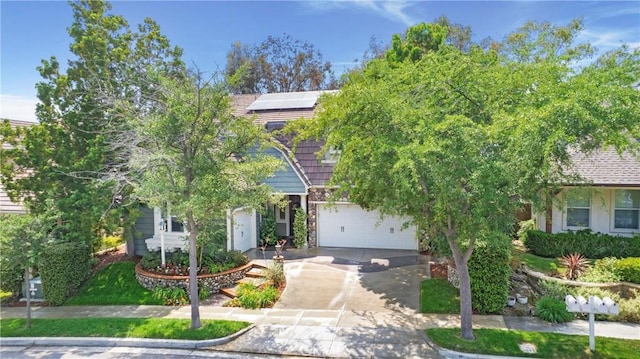 15 Beacon, Ladera Ranch, CA 92694 - view of property hidden behind natural elements with concrete driveway, solar panels, and an attached garage