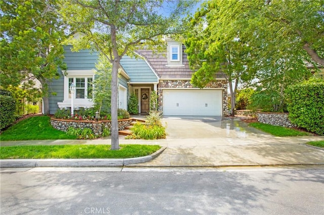 15 Beacon, Ladera Ranch, CA 92694 - view of property hidden behind natural elements featuring stone siding, driveway, and an attached garage