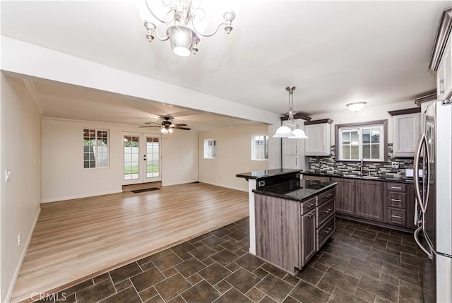 21323 Martin St, Carson, CA 90745 - kitchen featuring dark countertops, stainless steel refrigerator, tasteful backsplash, a chandelier, and open floor plan