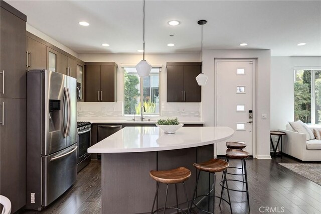 5515 Palm Dr, Hawthorne, CA 90250 - kitchen featuring appliances with stainless steel finishes, a kitchen bar, light countertops, a sink, and dark wood finished floors