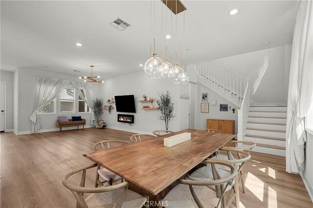 27010 Declaration Rd, Valencia, CA 91381 - dining space featuring stairs, light wood-style flooring, recessed lighting, baseboards, and a glass covered fireplace
