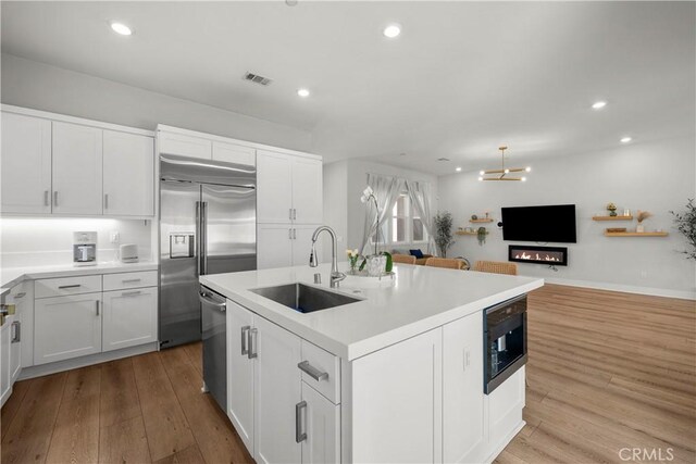 27010 Declaration Rd, Valencia, CA 91381 - kitchen featuring a sink, built in appliances, wood finished floors, white cabinetry, and recessed lighting