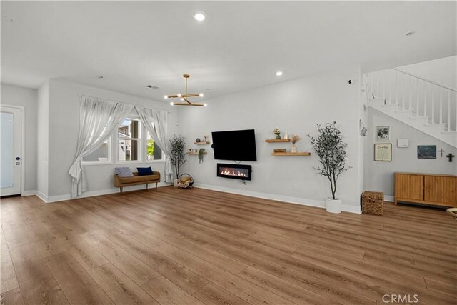 27010 Declaration Rd, Valencia, CA 91381 - unfurnished living room featuring wood finished floors, stairs, a chandelier, recessed lighting, and baseboards