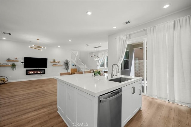27010 Declaration Rd, Valencia, CA 91381 - kitchen featuring stainless steel dishwasher, a sink, a chandelier, light wood finished floors, and white cabinets