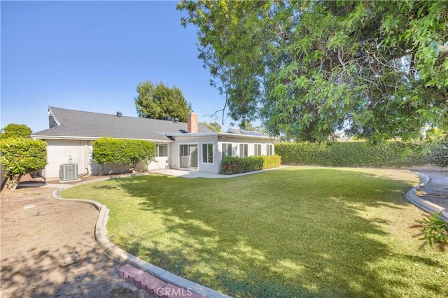 12151 Reagan St, Los Alamitos, CA 90720 - back of house with cooling unit, a yard, a chimney, a patio area, and stucco siding