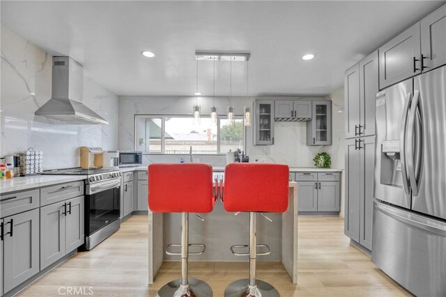 1158 N Ivescrest Ave, Covina, CA 91724 - kitchen featuring stainless steel appliances, gray cabinetry, wall chimney range hood, backsplash, and recessed lighting