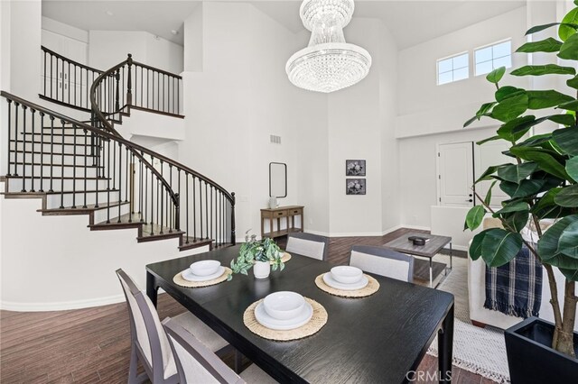 16209 Eagleridge Ct, La Mirada, CA 90638 - dining room with wood finished floors, a chandelier, stairway, a towering ceiling, and baseboards