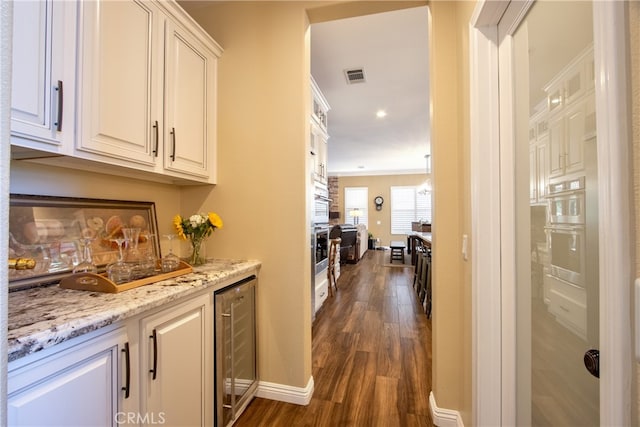 42926 Joshua Tree Ct, Murrieta, CA 92562 - indoor wet bar featuring wine cooler, dark wood-type flooring, baseboards, and double oven