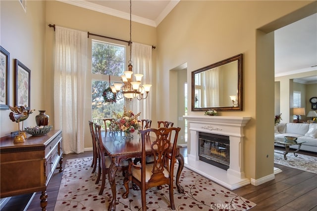 42926 Joshua Tree Ct, Murrieta, CA 92562 - dining space with a chandelier, dark wood-type flooring, ornamental molding, a glass covered fireplace, and baseboards