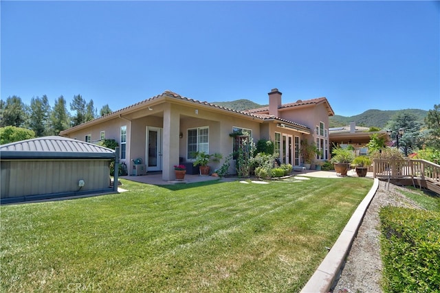 42926 Joshua Tree Ct, Murrieta, CA 92562 - back of house with a chimney, stucco siding, a patio area, a lawn, and a tiled roof