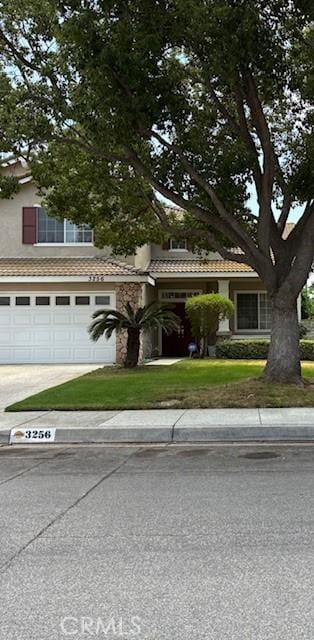 3256 Stallion St, Ontario, CA 91761 - obstructed view of property featuring an attached garage, concrete driveway, and a tiled roof