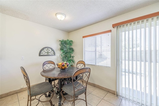 45409 Rodin Ave, Lancaster, CA 93535 - dining room with light tile patterned floors, baseboards, and a textured ceiling