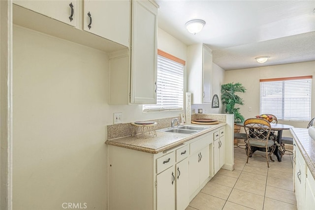 45409 Rodin Ave, Lancaster, CA 93535 - kitchen featuring a sink, white cabinets, light tile patterned floors, and light countertops
