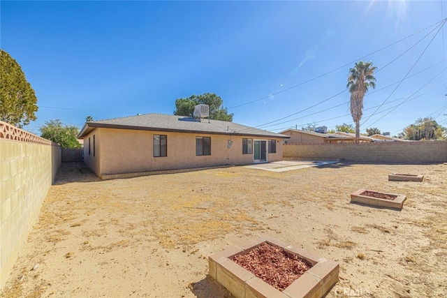 45409 Rodin Ave, Lancaster, CA 93535 - back of property with a fenced backyard, a patio, stucco siding, and a vegetable garden