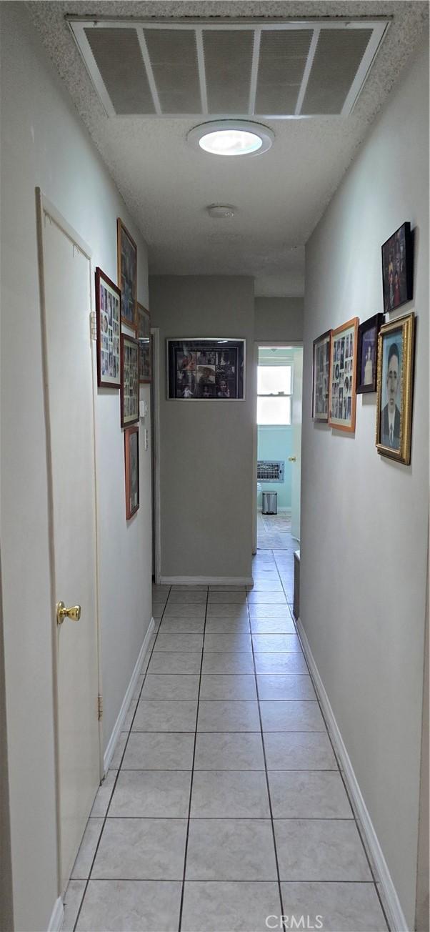 8106 Bevis Ave, Panorama City, CA 91402 - hallway with light tile patterned flooring and baseboards