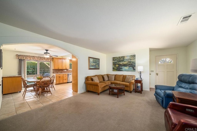 905 Discovery St, San Marcos, CA 92078 - living room featuring arched walkways, light colored carpet, ceiling fan, and light tile patterned flooring
