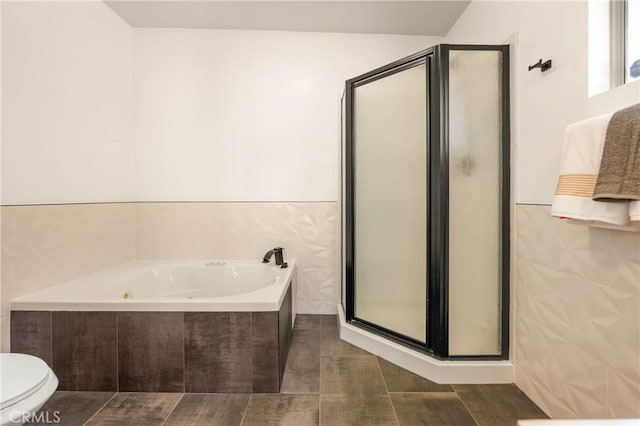589 S Mountain View Dr, Palm Springs, CA 92264 - bathroom featuring a stall shower, tile walls, a garden tub, and toilet