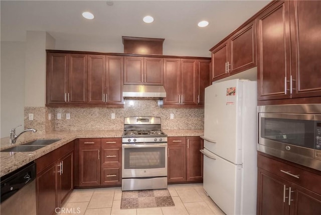 3212 Willow Creek Rd, West Covina, CA 91791 - kitchen with stainless steel appliances, under cabinet range hood, a sink, light stone countertops, and decorative backsplash