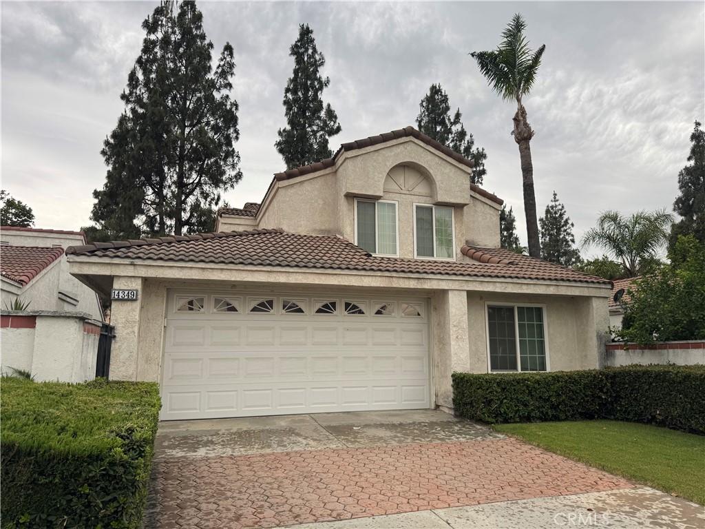 14349 El Contento Ave, Fontana, CA 92337 - view of front facade with driveway, stucco siding, a tile roof, and an attached garage