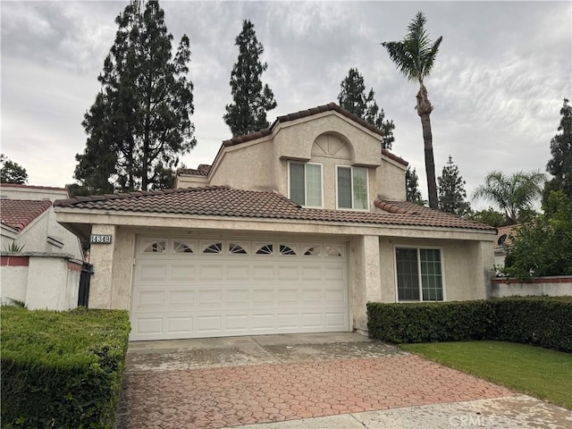 14349 El Contento Ave, Fontana, CA 92337 - view of front facade with driveway, stucco siding, a tile roof, and an attached garage