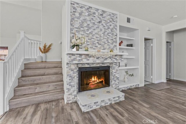 27051 Featherhill Dr, Corona, CA 92883 - living area with wood finished floors, stairway, built in features, and a fireplace
