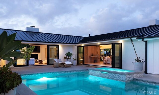 1936 Galaxy Dr, Newport Beach, CA 92660 - rear view of house with a standing seam roof, metal roof, a chimney, and stucco siding