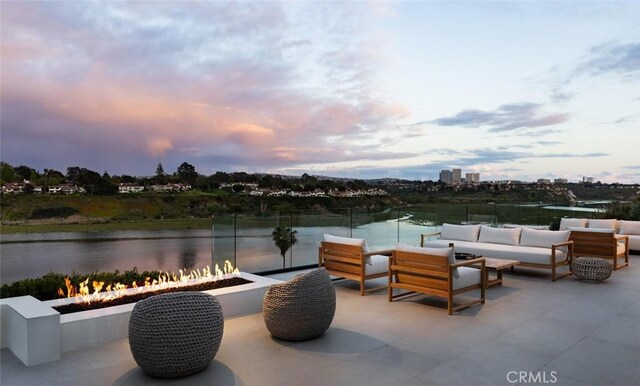 1936 Galaxy Dr, Newport Beach, CA 92660 - patio terrace at dusk featuring an outdoor living space with a fire pit, a water view, and a patio