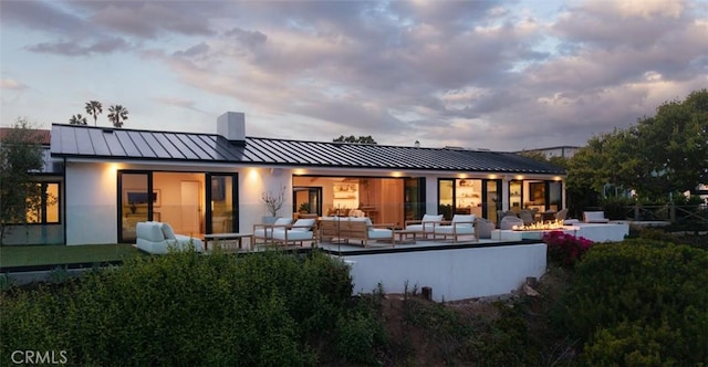 1936 Galaxy Dr, Newport Beach, CA 92660 - back of property with a standing seam roof, an outdoor living space with a fire pit, metal roof, and a chimney