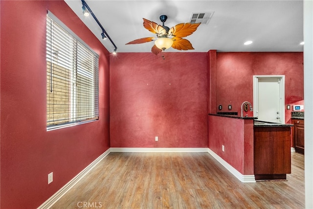 19539 Laroda, Saugus, CA 91350 - kitchen featuring wood finished floors, ceiling fan, baseboards, rail lighting, and dark countertops