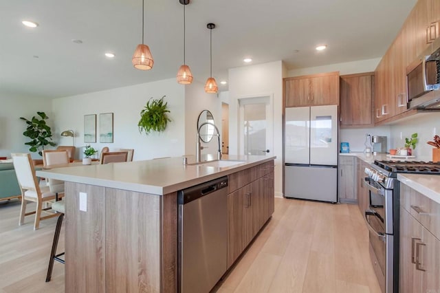 35140 Bergamot, Fallbrook, CA 92028 - kitchen featuring stainless steel appliances, light wood-style floors, light countertops, an island with sink, and recessed lighting