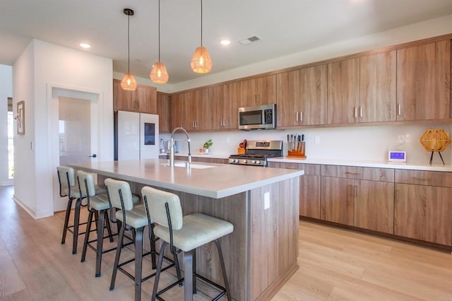 35140 Bergamot, Fallbrook, CA 92028 - kitchen featuring stainless steel appliances, brown cabinetry, a breakfast bar area, light wood finished floors, and recessed lighting