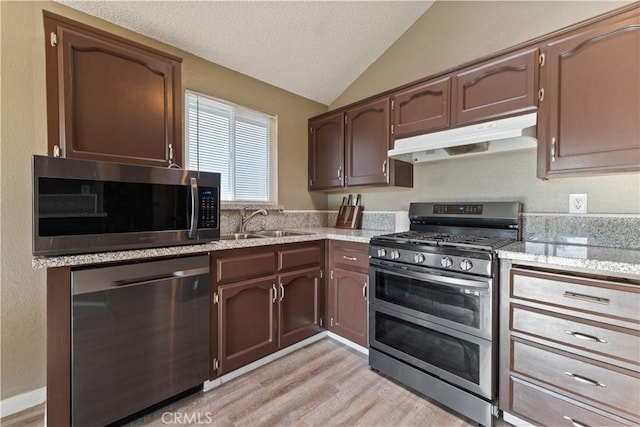 2433 N Knoll Ave, Fresno, CA 93722 - kitchen with stainless steel appliances, under cabinet range hood, vaulted ceiling, a textured ceiling, and a sink