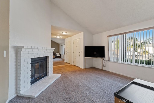2433 N Knoll Ave, Fresno, CA 93722 - unfurnished living room featuring carpet, vaulted ceiling, a brick fireplace, and baseboards