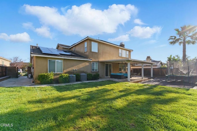29039 Shorecliff Cir, Menifee, CA 92585 - back of house with a trampoline, a patio area, stucco siding, solar panels, and a ceiling fan