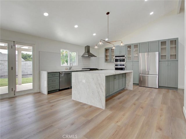 436 Cheyenne Pl, Placentia, CA 92870 - kitchen with appliances with stainless steel finishes, wall chimney exhaust hood, a kitchen island, light wood-style floors, and lofted ceiling