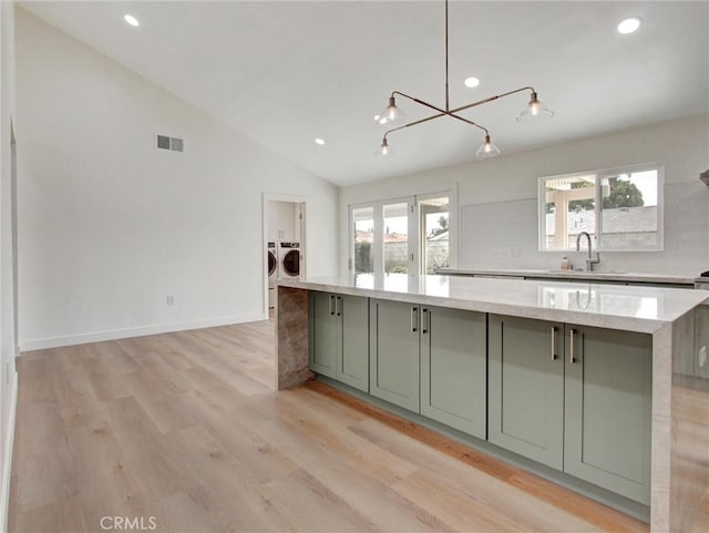 436 Cheyenne Pl, Placentia, CA 92870 - kitchen featuring washing machine and dryer, a sink, a spacious island, lofted ceiling, and plenty of natural light