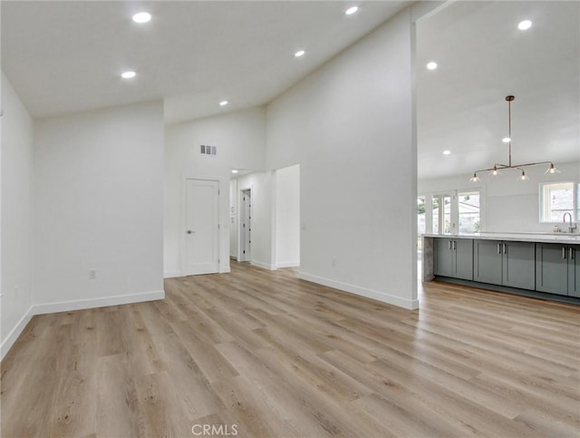 436 Cheyenne Pl, Placentia, CA 92870 - unfurnished living room featuring high vaulted ceiling, light wood-style flooring, recessed lighting, baseboards, and a sink