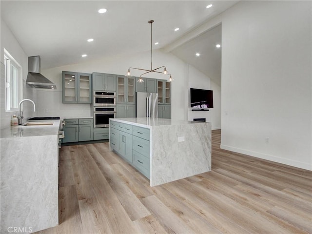436 Cheyenne Pl, Placentia, CA 92870 - kitchen featuring wall chimney exhaust hood, stainless steel appliances, a center island, lofted ceiling, and light wood-style flooring