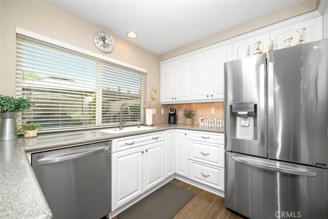 6898 Breton Way, Cypress, CA 90630 - kitchen featuring appliances with stainless steel finishes, a sink, dark wood-type flooring, white cabinets, and decorative backsplash