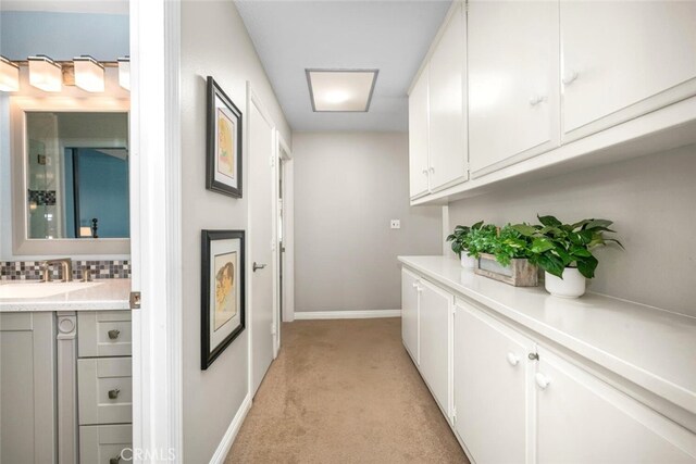6898 Breton Way, Cypress, CA 90630 - hallway featuring a sink, light carpet, and baseboards